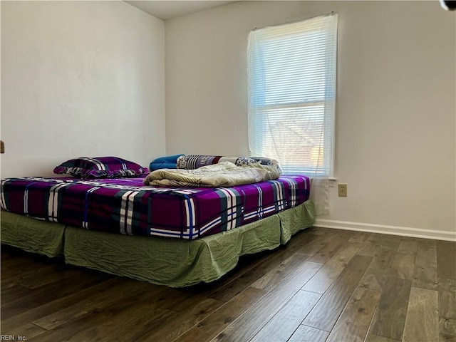 bedroom with baseboards and wood finished floors