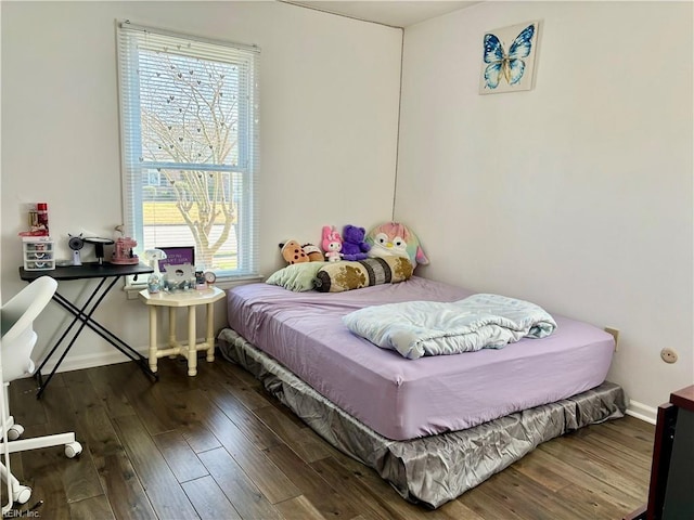 bedroom with baseboards and wood finished floors