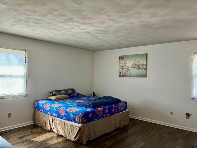 bedroom with baseboards and wood finished floors