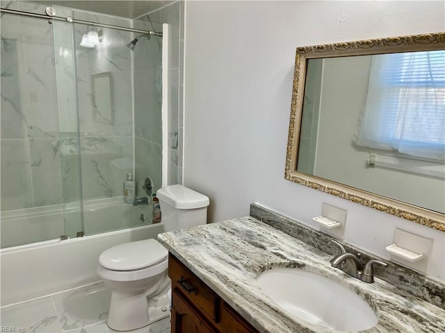 bathroom with toilet, marble finish floor, enclosed tub / shower combo, and vanity