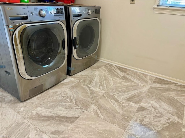 laundry room featuring marble finish floor, laundry area, independent washer and dryer, and baseboards