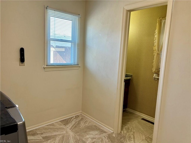 bathroom featuring curtained shower and baseboards