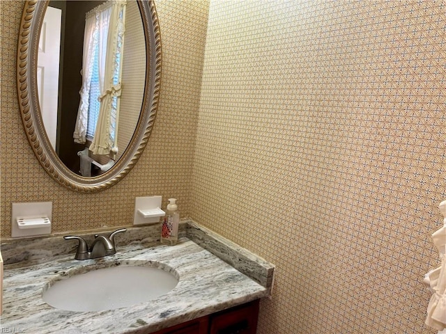 bathroom with wallpapered walls and vanity