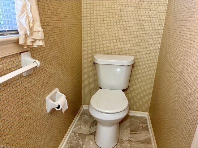 bathroom with toilet and baseboards