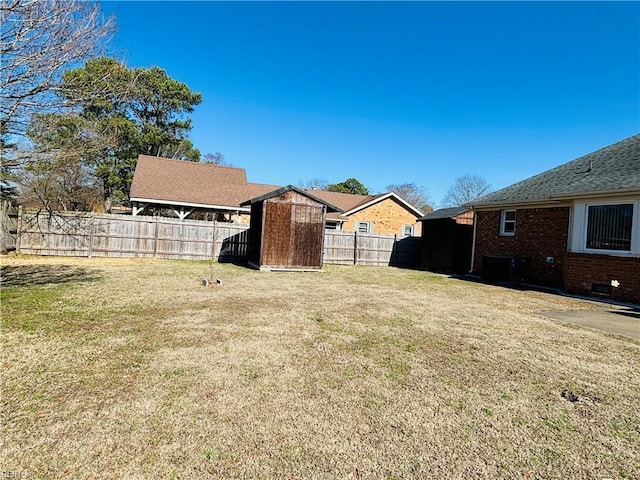 view of yard with a fenced backyard, a storage unit, and an outdoor structure