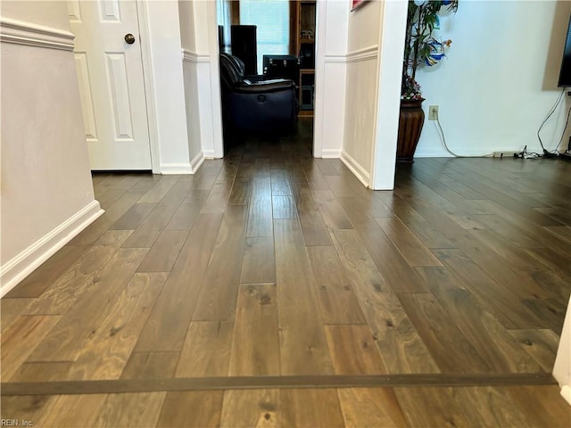 corridor featuring dark wood-style floors and baseboards