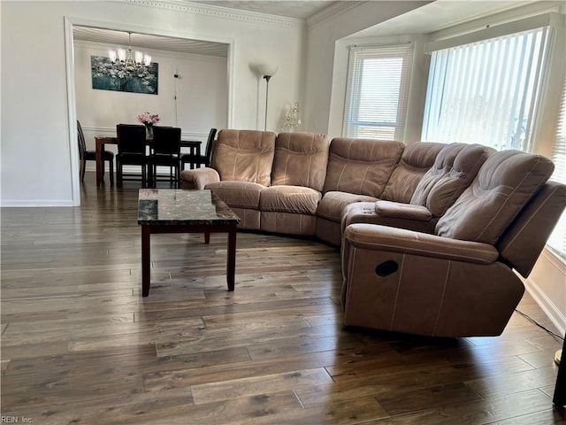 living room featuring baseboards, ornamental molding, a chandelier, and dark wood-style flooring