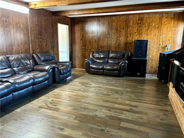 living room with hardwood / wood-style flooring, beam ceiling, and wood walls