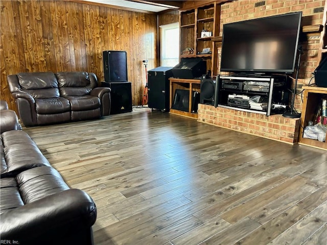 living area with wooden walls, beam ceiling, and wood finished floors