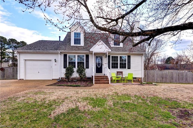 new england style home featuring a shingled roof, a front yard, fence, and an attached garage