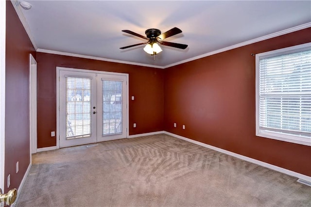 carpeted empty room with french doors, visible vents, ornamental molding, ceiling fan, and baseboards