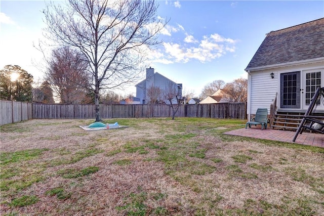 view of yard featuring entry steps, french doors, a fenced backyard, and a patio