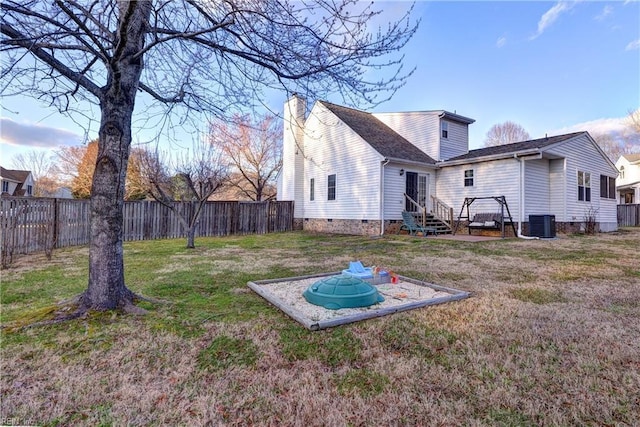 back of house with a yard, a chimney, entry steps, crawl space, and a fenced backyard