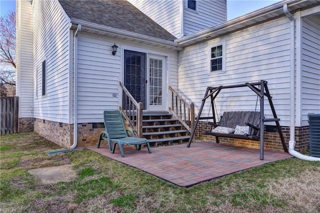 property entrance featuring a patio, roof with shingles, crawl space, fence, and a yard