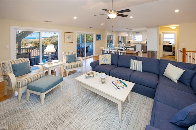 living area with light wood finished floors, visible vents, and recessed lighting