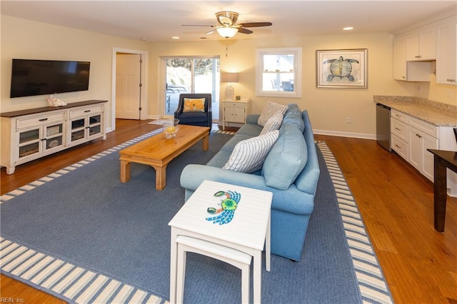 living area featuring recessed lighting, wood finished floors, a ceiling fan, baseboards, and built in study area