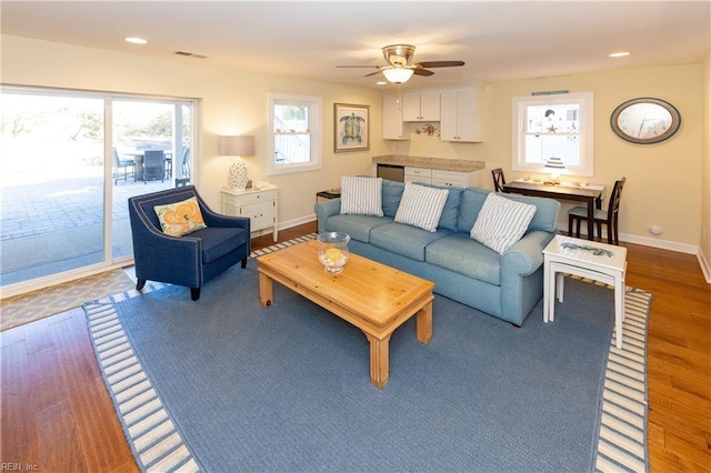 living room with ceiling fan, recessed lighting, wood finished floors, visible vents, and baseboards