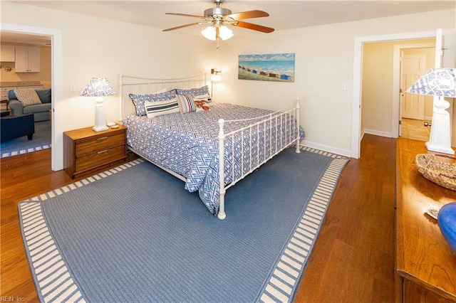 bedroom featuring ceiling fan, wood finished floors, and baseboards