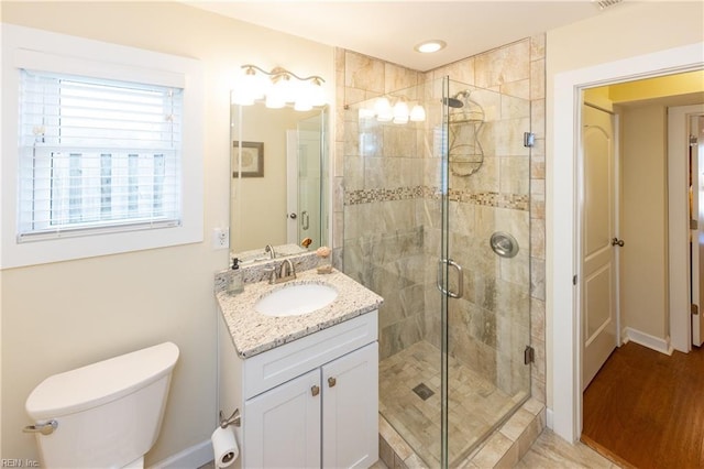 full bathroom with a stall shower, vanity, and toilet