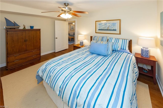 bedroom with ceiling fan, baseboards, and wood finished floors