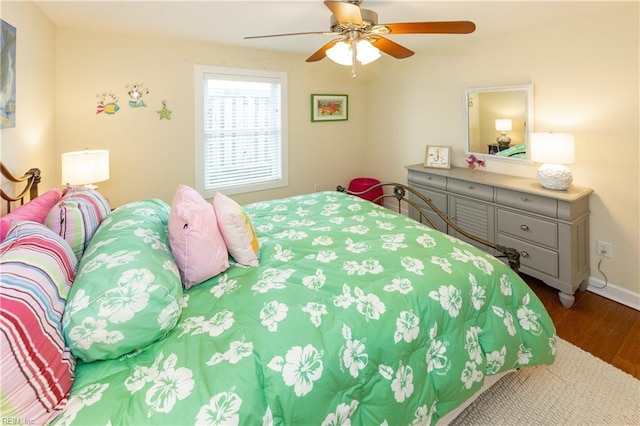 bedroom with ceiling fan, baseboards, and wood finished floors