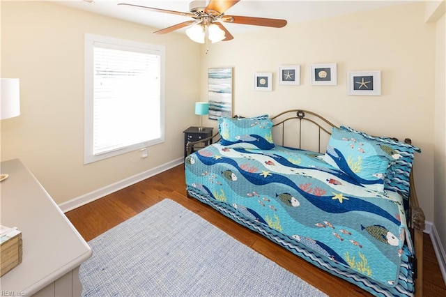 bedroom with ceiling fan, baseboards, and wood finished floors