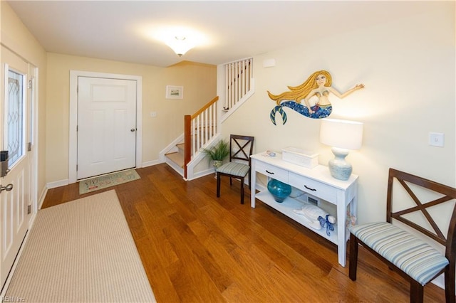 entryway featuring stairway, wood finished floors, and baseboards