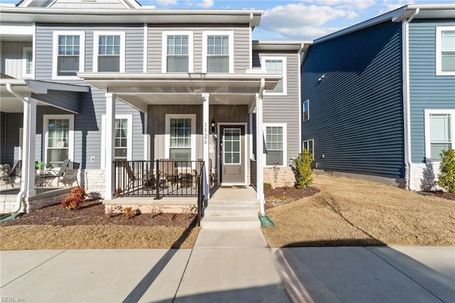 townhome / multi-family property featuring covered porch