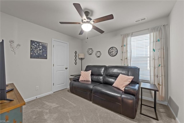 carpeted living room featuring a ceiling fan, visible vents, and baseboards