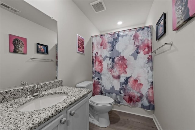 bathroom featuring toilet, visible vents, wood finished floors, and vanity