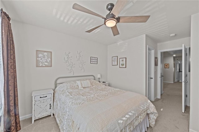 bedroom with a ceiling fan, light colored carpet, and baseboards