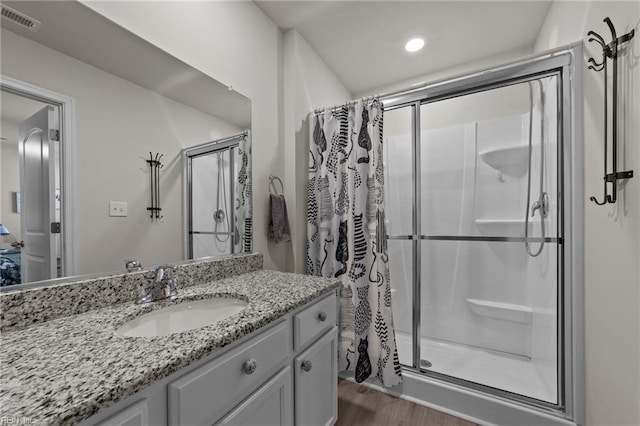 full bath with vanity, a shower stall, and visible vents