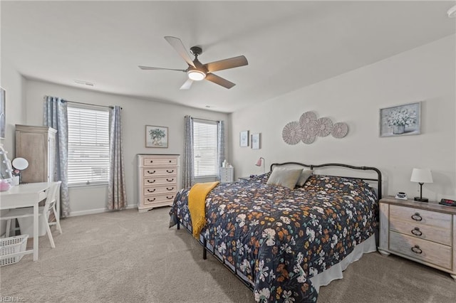 carpeted bedroom with a ceiling fan, multiple windows, and baseboards