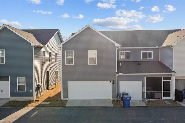 back of house featuring a garage and driveway