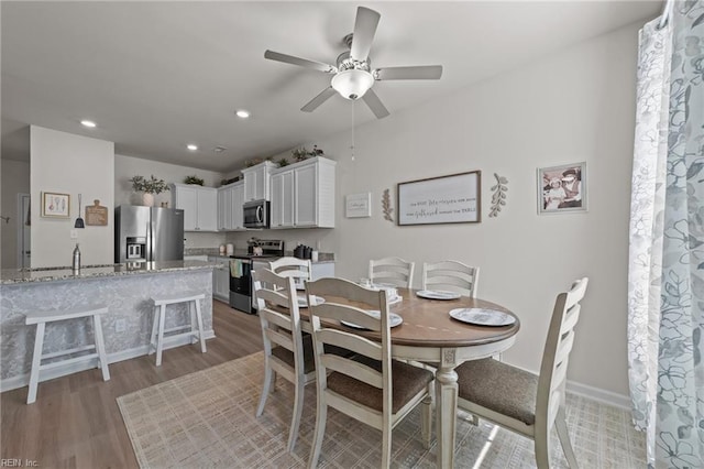 dining space with baseboards, recessed lighting, a ceiling fan, and light wood-style floors