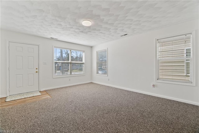 interior space featuring visible vents, baseboards, and a textured ceiling