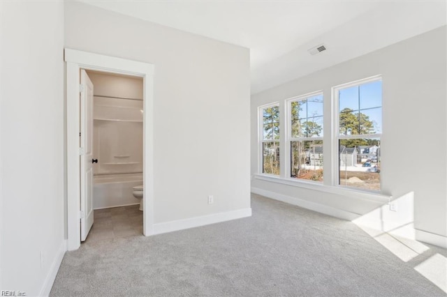 unfurnished bedroom with carpet floors, visible vents, and baseboards