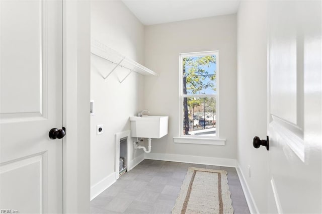 clothes washing area featuring laundry area, electric dryer hookup, and baseboards