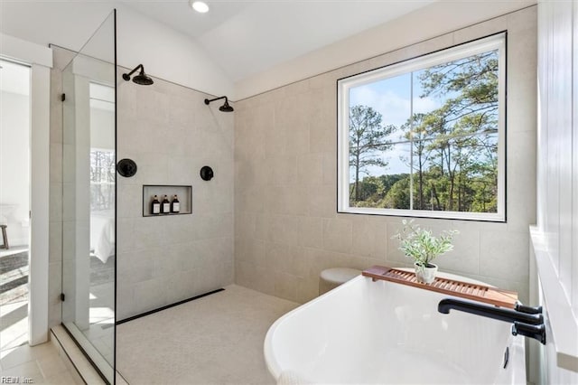 full bathroom with a soaking tub, vaulted ceiling, a sink, and a walk in shower