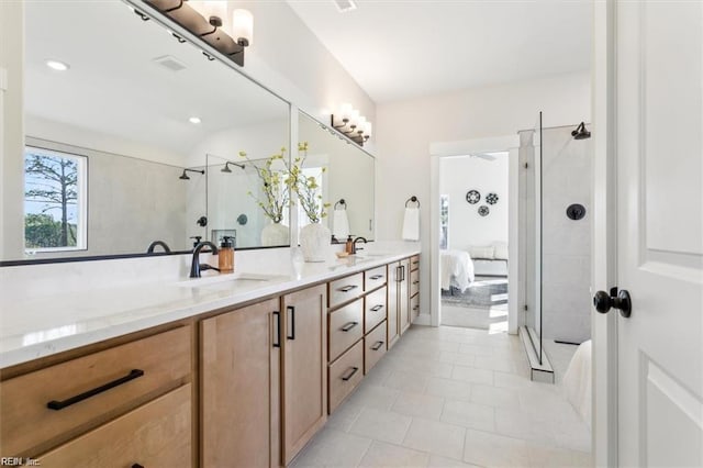 ensuite bathroom featuring double vanity, ensuite bath, a shower stall, and a sink