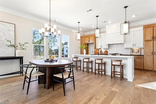 dining room featuring light wood finished floors, visible vents, a notable chandelier, and recessed lighting