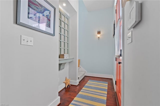 hall featuring stairs, baseboards, and dark wood finished floors