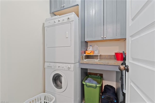 washroom with stacked washer and dryer and cabinet space