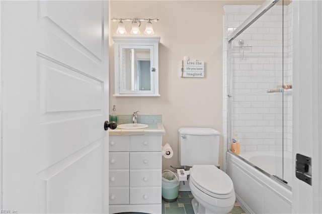 bathroom featuring toilet, enclosed tub / shower combo, and vanity