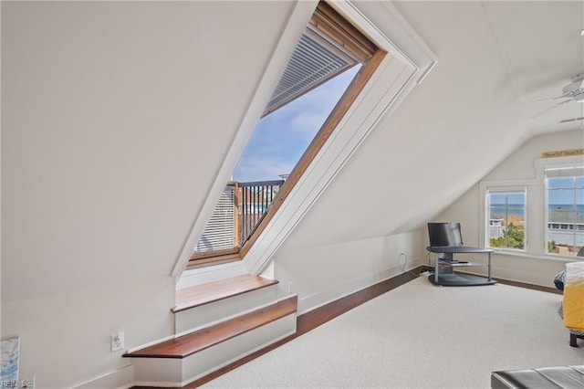 interior space featuring vaulted ceiling, ceiling fan, and baseboards