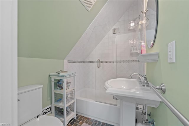 bathroom featuring toilet, shower / bath combination with glass door, and lofted ceiling