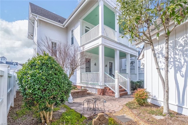 property entrance with a porch, a patio area, and a balcony