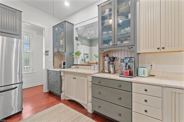 kitchen with freestanding refrigerator, gray cabinets, backsplash, and dark wood-style flooring