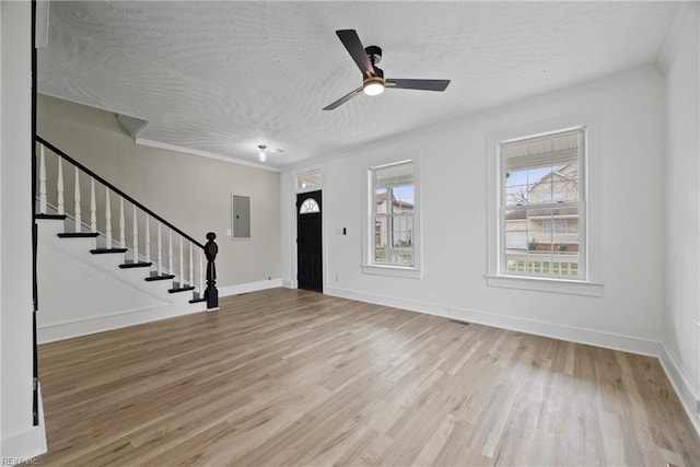 entrance foyer with baseboards, stairway, electric panel, wood finished floors, and a textured ceiling