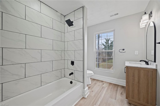 bathroom with visible vents, toilet, shower / bathtub combination, baseboards, and vanity